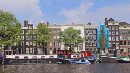 Small boats moored next to residential houses in Amstel river  canal inside the city of Amsterdam