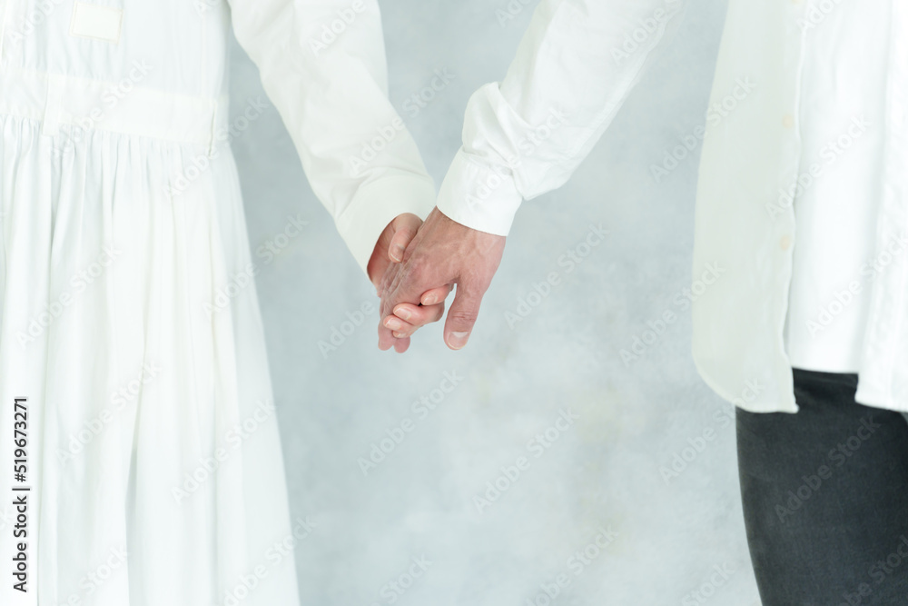 手を繋ぐ中高年のカップル