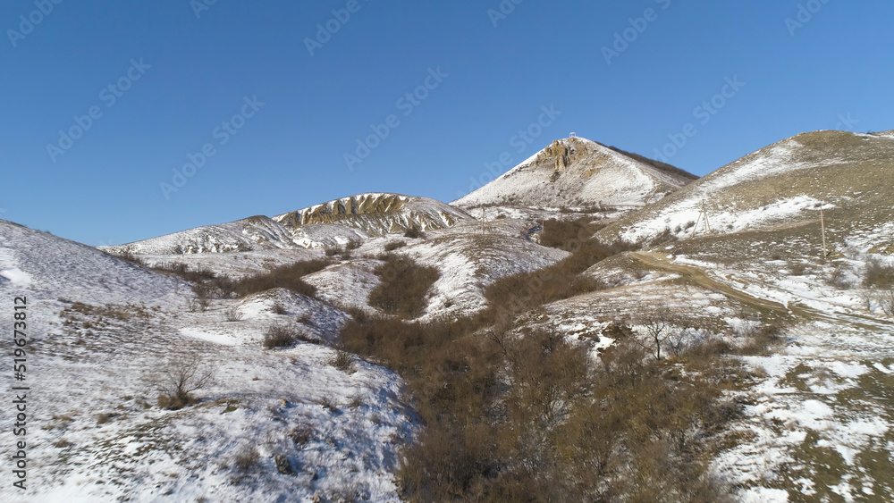 Alps - aerial view. Mountains under the snow in winter. Panorama of snow mountain range landscape with blue sky