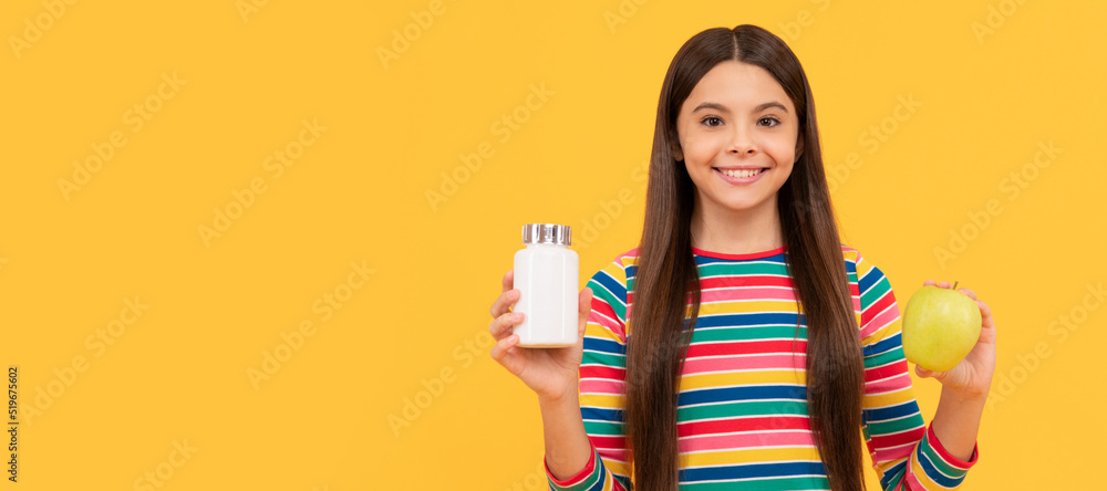 Happy kid hold apple fruit and medicine bottle yellow background, supplement. Horizontal poster of isolated child face, banner header, copy space. Happy kid hold apple fruit and medicine bottle yellow background, supplement. Horizontal poster of isolated child face, banner header, copy space.