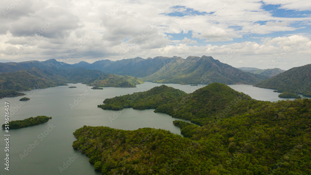 A lake with islands surrounded by mountains with a tropical forest. Randenigala reservoir.