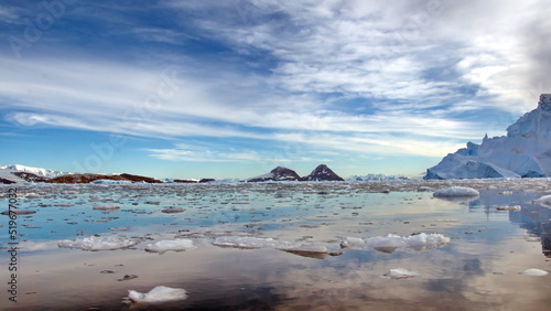 Small bits of ice floating in the bay in front of snow covered mountains at Cierva Cove  Antarctica