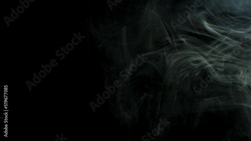 Smoke fragments flowing on black background. Stock footage. Beautiful white clouds of smoke moving slowly isolated on dark background.