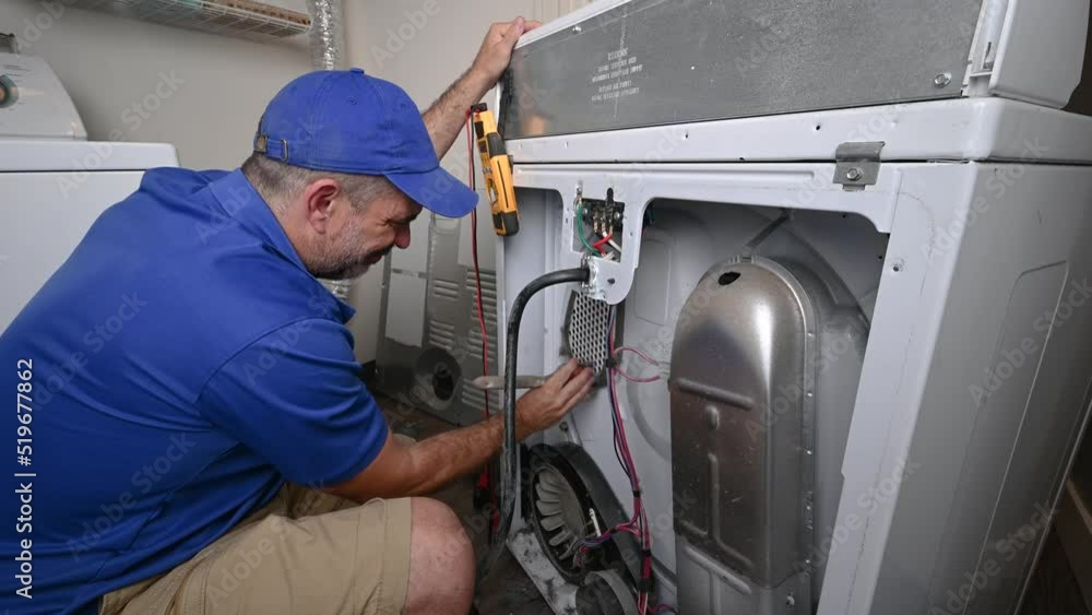 Appliance Technician Cleaning an Electric Dryer Appliance Technician Cleaning an Electric Dryer