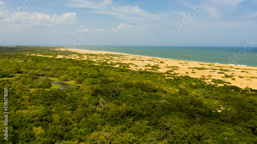 Wild beach and ocean in Kumana national park surrounded by jungle.
