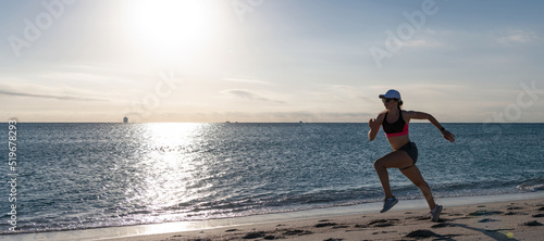 Woman run and jump on sea beach. Active woman runner in sportswear run on beach sand along seaside, running.