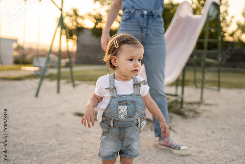 girl toddler small child stand by her mother in park in day copy space