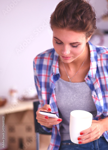 Young woman reading mgazine In kitchen at home photo