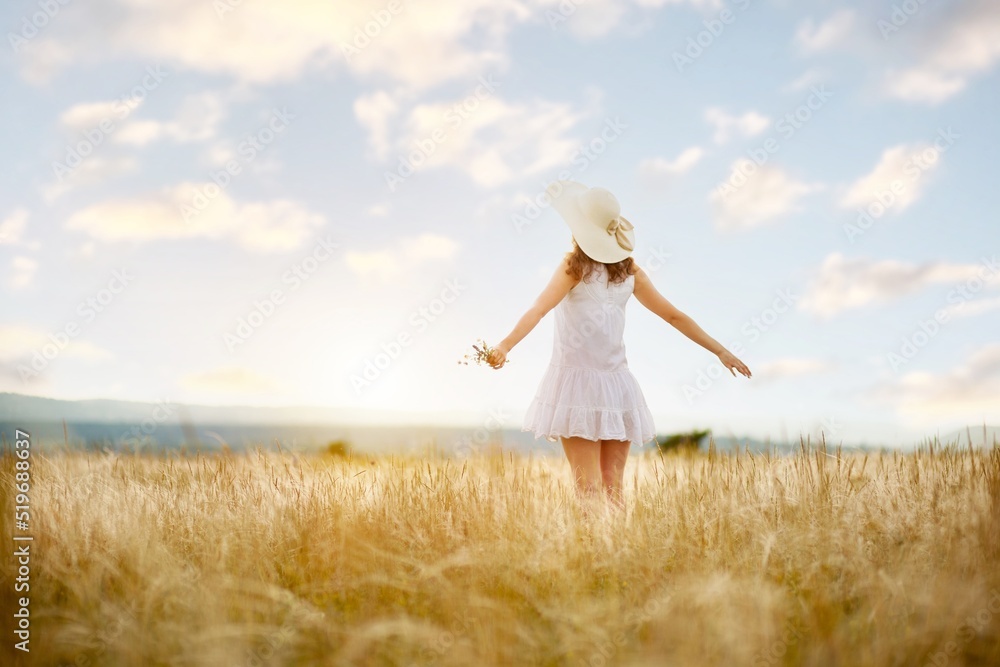 Woman in hat on the field with flowers on the field background Woman in hat on the field with flowers on the field background