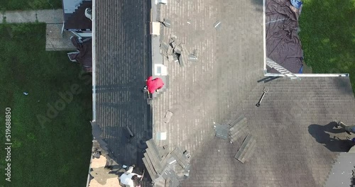Birds Eye View over Roofers Removing and Tossing Shingles