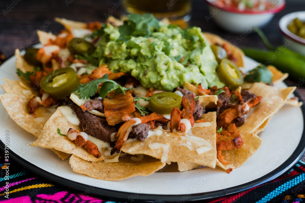 Mexican nachos chips with american cheese and avocado, traditional food in Mexico Latin America Mexican nachos chips with american cheese and avocado, traditional food in Mexico Latin America