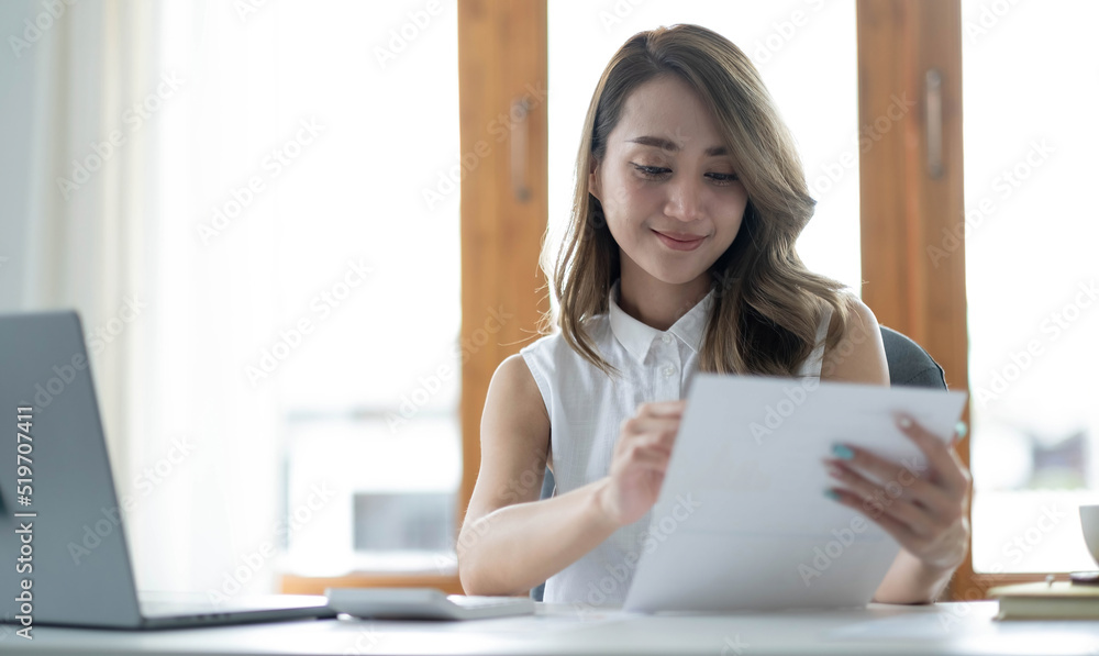 Beautiful young asian woman sitting at coffee shop using laptop. Happy young businesswoman sitting at table in cafe with tab top computer. Beautiful young asian woman sitting at coffee shop using laptop. Happy young businesswoman sitting at table in cafe with tab top computer.