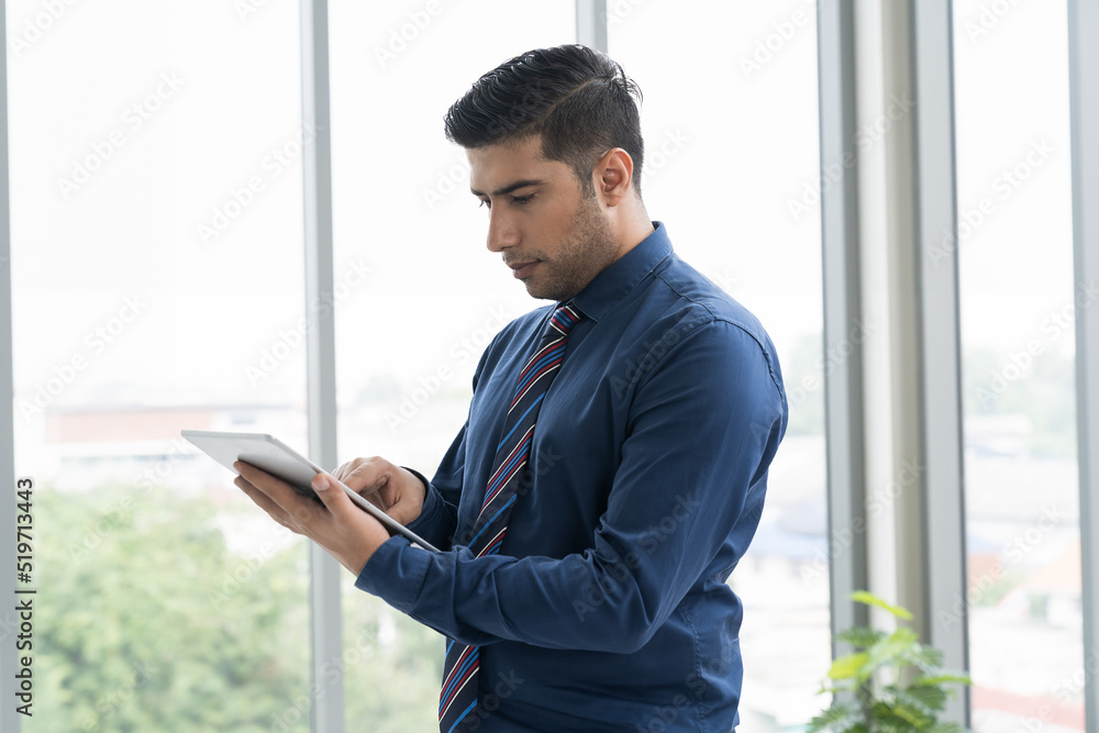 Businessman standing and working with digital tablet at the workspace office. Businessman standing and working with digital tablet at the workspace office.