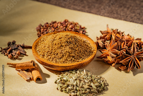 Chinese traditional seasoning five spice powder and raw materials on retro background 