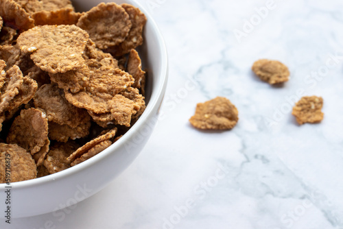 Bowl of multigrain cereal with spoon on marble table background. Healthy diet breakfast. Top view, copy space