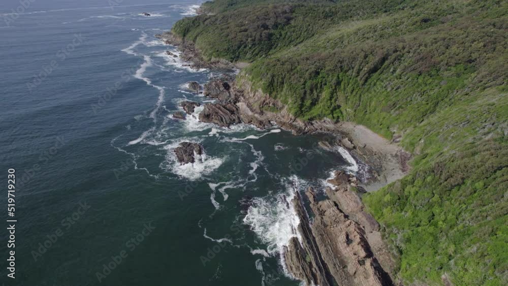Foamy Waves Splashing On Rocky Green Cliffs In Forster, Australia - aerial drone shot Foamy Waves Splashing On Rocky Green Cliffs In Forster, Australia - aerial drone shot