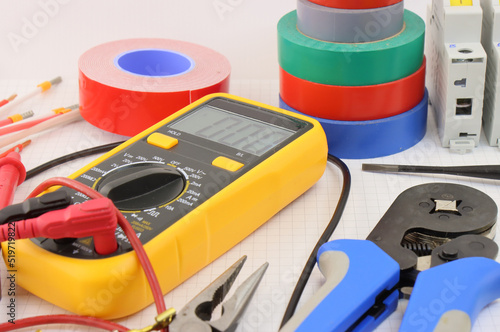Multimeter and tools for installing an electrical control panel in close-up on. 