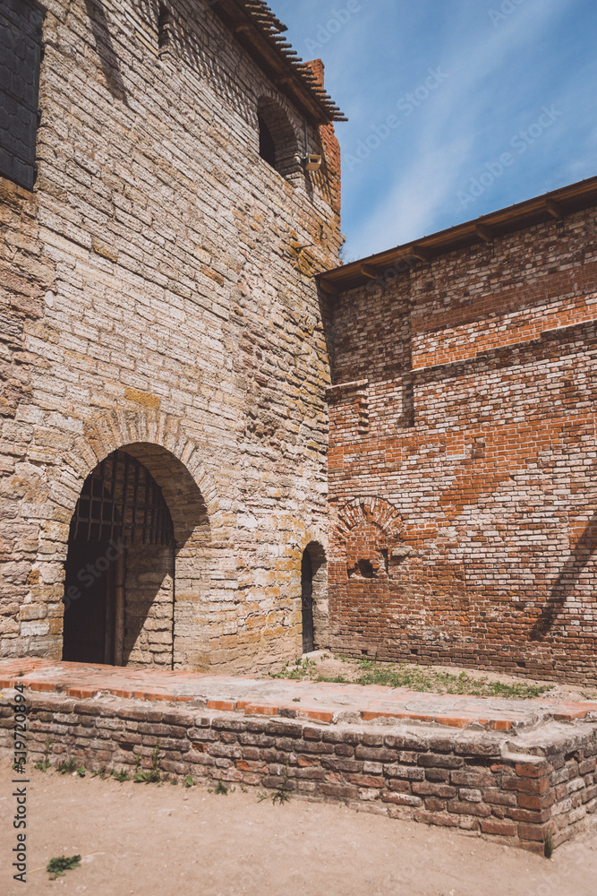 Arched entrance to the ancient brick fortress. photo vertical