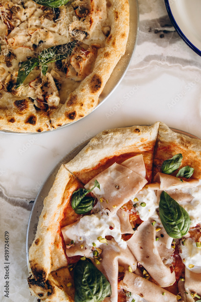 Foto de two pizzas closeup on a white marble table top view