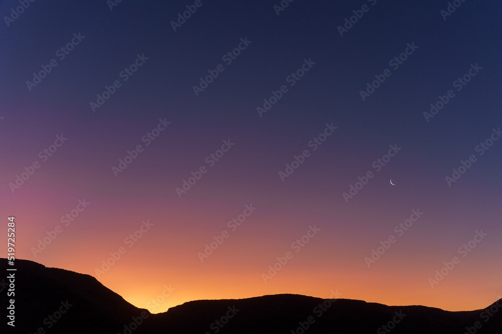 Sunset sky, crescent moon and scenic view of Karoo National Park, Beaufort West, Western Cape, South Africa