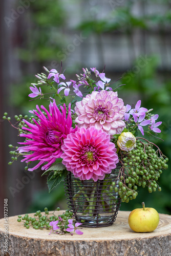 Blumenstrauß mit pink Dahlien, Holunderbeeren und Spinnenblumen in vintage Vase photo