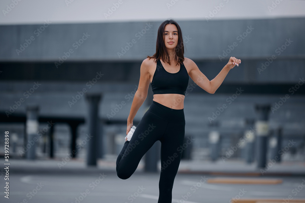 Fitness runner body close up, woman doing warm-up before jogging, stretching leg muscles, Female athlete prepares legs for cardio workout, outdoor exercise in city