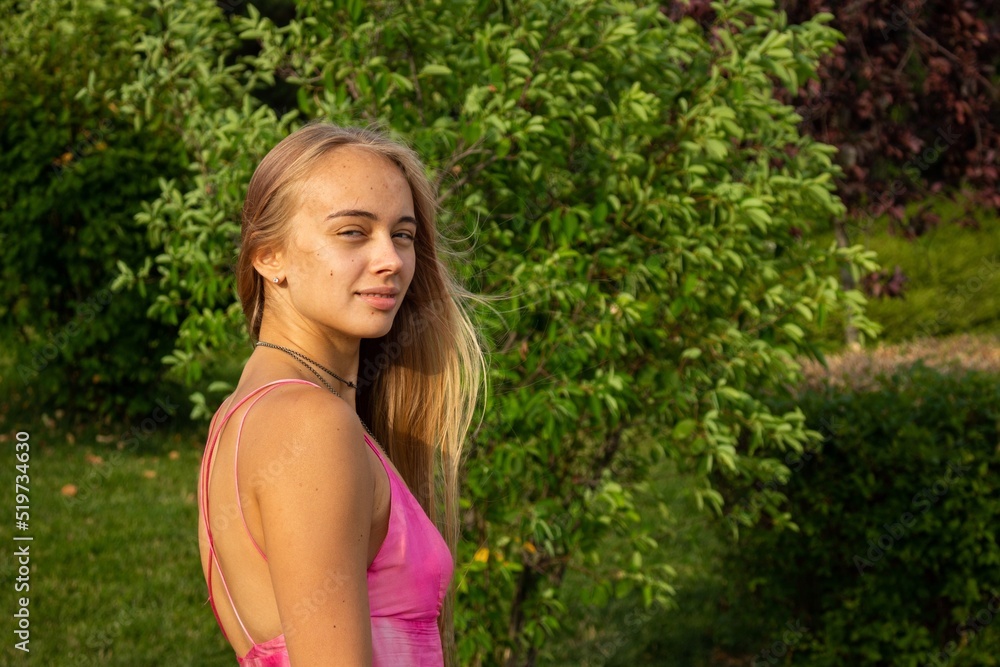 beautiful blonde in a pink dress walks along the promenade beautiful blonde in a pink dress walks along the promenade