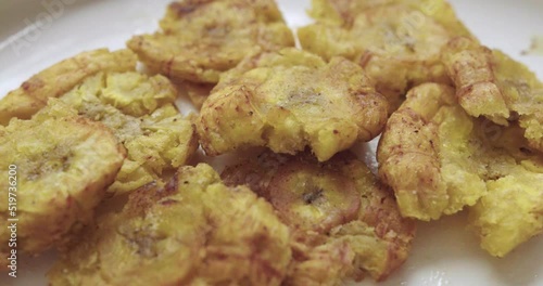 Close-up of a group of fried patacones or tostones freshly cooked and placed on a plate. photo