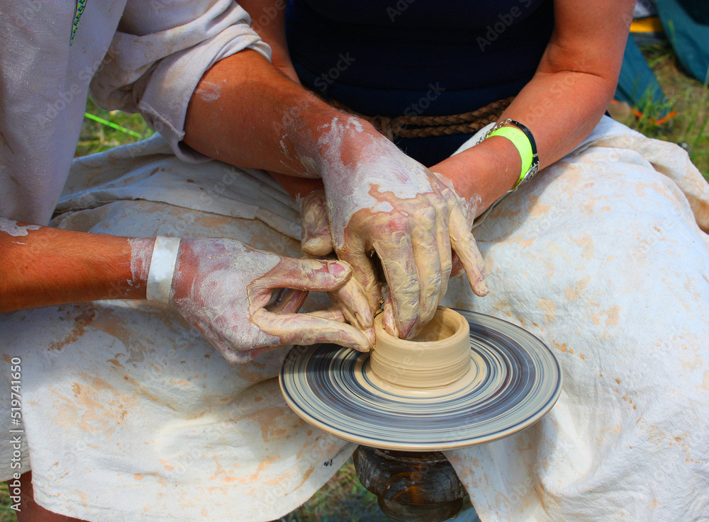 Close up view of the hands, potter and  potter's potter's wheel