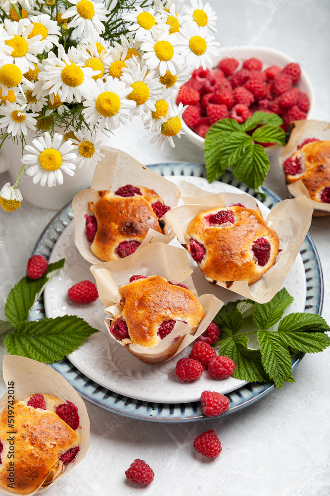 muffins with raspberries on a light table decorated in a summer style. concept home baking, summer baking, holiday, summer tea party, dessert, summer desserts, romantic evening, valentine's day