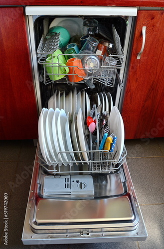 Open dishwasher with clean dishes, close up. Dishwasher after cleaning process.
