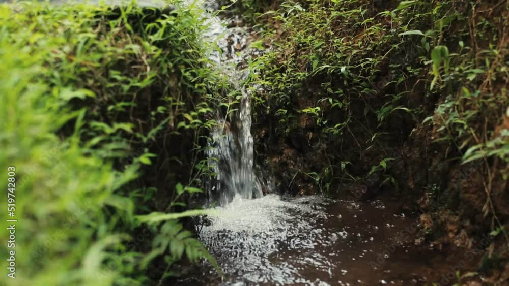 Close up gimbal shot of a small stream of water running in uneven terrain Close up gimbal shot of a small stream of water running in uneven terrain