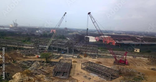 Industrial Cranes At The Construction Site Building The Structural Frame Of Building In Paradip Port. - aerial photo