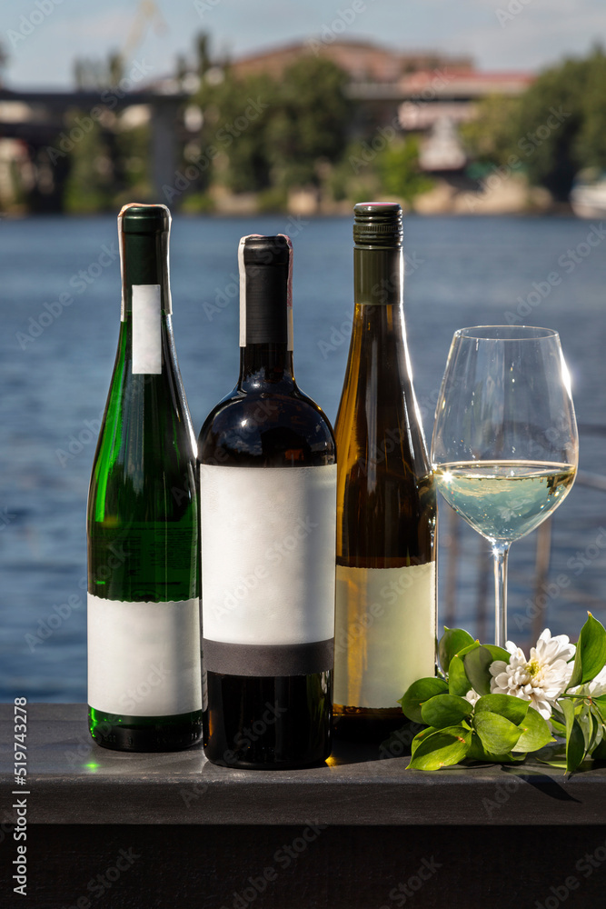 Three bottles of wine with a glass