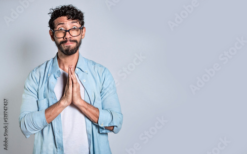 Man putting his hands together asking for a favor, Pleading person asking for a favor, People with a pleading expression asking for a favor.