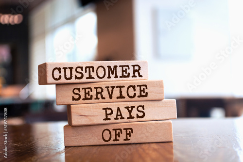Wooden blocks with words 'Customer service pays off'. Business concept