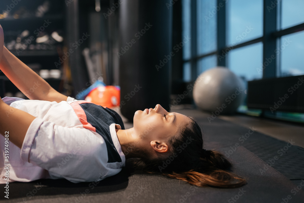 Fototapeta premium Young woman doing exercises in the gym