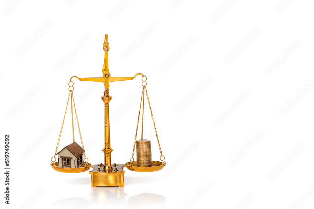Small wooden house and stacked golden coins on weighing scales isolated on white background. Mortgage and real estate investment concept. Copy space. Small wooden house and stacked golden coins on weighing scales isolated on white background. Mortgage and real estate investment concept. Copy space.