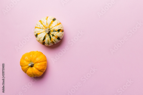 Autumn composition of little orange pumpkins on colored table background. Fall, Halloween and Thanksgiving concept. Autumn flat lay photography. Top view vith copy space