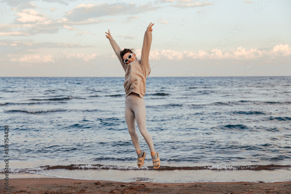 Funny happy woman jumping on beach looking at camera Funny happy woman jumping on beach looking at camera