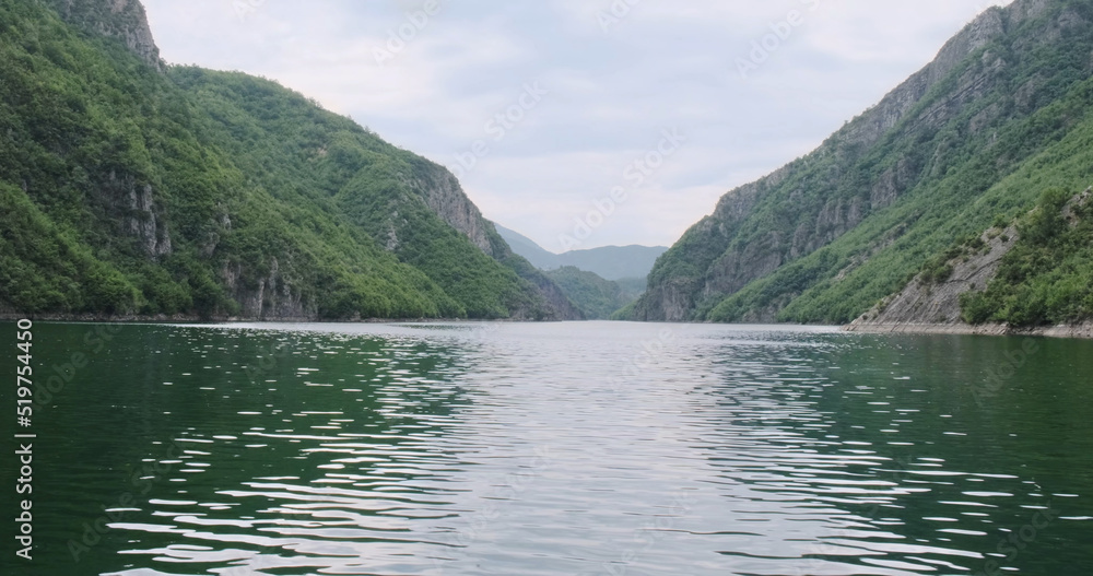 Beautiful green nature in mountains, Komani lake in summer. Pure wild nature of Albania, lake travel. Fresh water river flowing. Panoramic scenic landscape Alps mountains. Explore nature outdoors