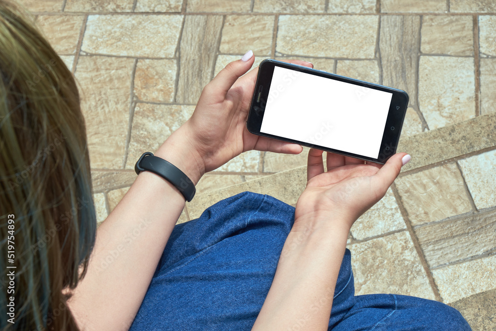 Young girl holding smartphone with white screen