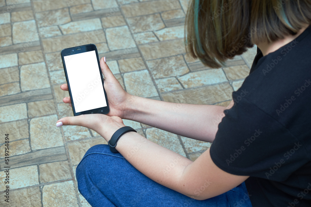 Young girl holding smartphone with white screen
