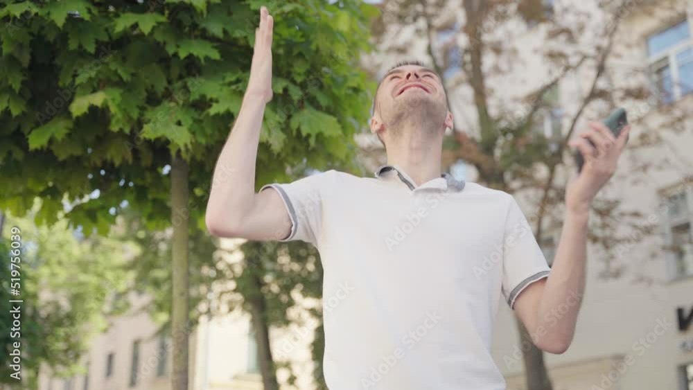 Portrait of happy European person looking at mobile phone, with emotion winner, financial stock sports betting. Young male celebrate success win victory. Lottery win concept. Portrait of happy European person looking at mobile phone, with emotion winner, financial stock sports betting. Young male celebrate success win victory. Lottery win concept.