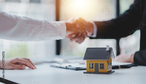 Handshake real estate agents deliver sample homes to customers. mortgage loan agreement Make a contract for hire purchase and sale of a house. and home insurance contracts home mortgage loan concept