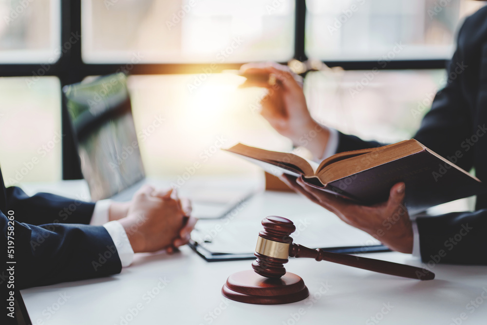 concept of justice and law A male judge in the courtroom on a wooden table and a male counselor or lawyer working in the office. Law, advice and justice concepts. concept of justice and law A male judge in the courtroom on a wooden table and a male counselor or lawyer working in the office. Law, advice and justice concepts.