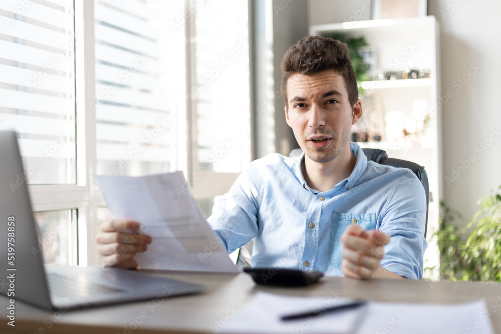 Angry man checking bills, financial problem, bank debt or lack of money, unhappy frustrated young male sitting at work desk with laptop and calculator. Angry man checking bills, financial problem, bank debt or lack of money, unhappy frustrated young male sitting at work desk with laptop and calculator.