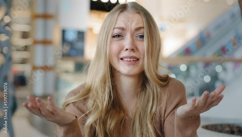 Puzzled Caucasian woman upset furious girl blonde lady indoor asks so what happened holding hands v looking dissatisfied at camera confused angry misunderstanding irritation reaction negative emotions photo