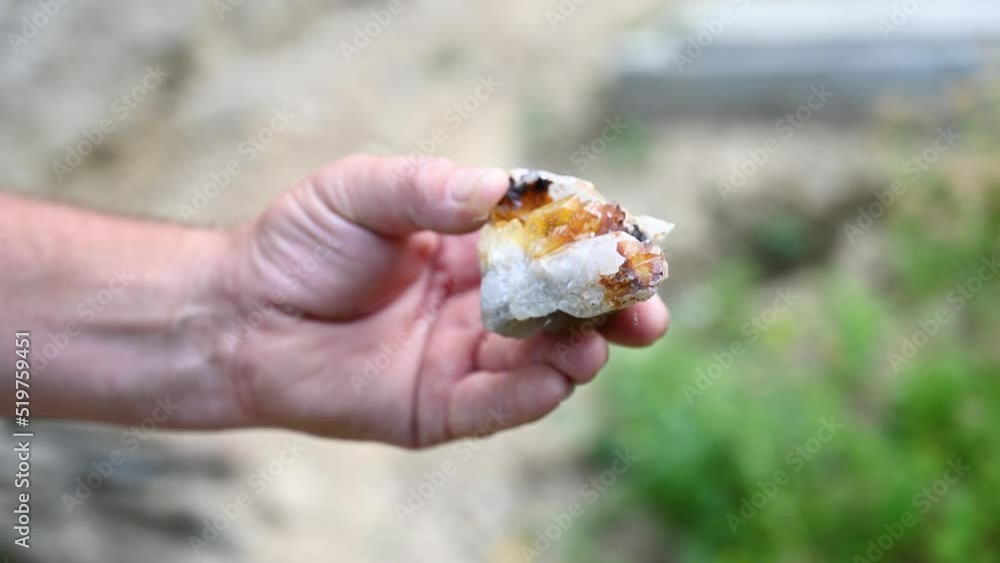 A man holds in his hand crystals that he found in nature. Unpolished Precious stones. Quartz. A man holds in his hand crystals that he found in nature. Unpolished Precious stones. Quartz.