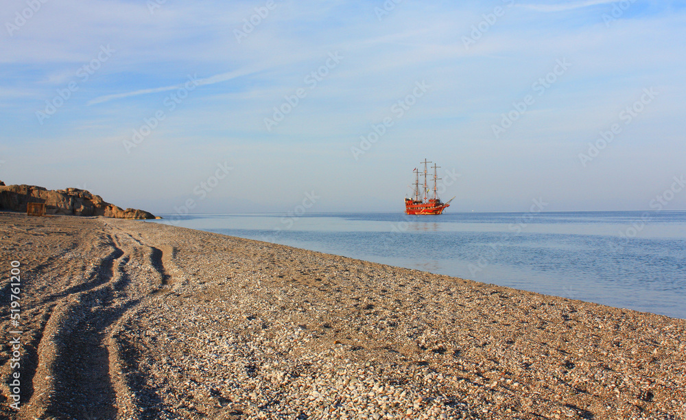Red sailing ship in the sea in sunset time Red sailing ship in the sea in sunset time